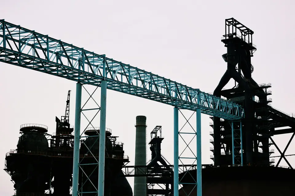 Silhouette of industrial conveyor structures against the sky